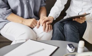 covid-recovery-center-female-doctor-checking-health-results-with-older-patient